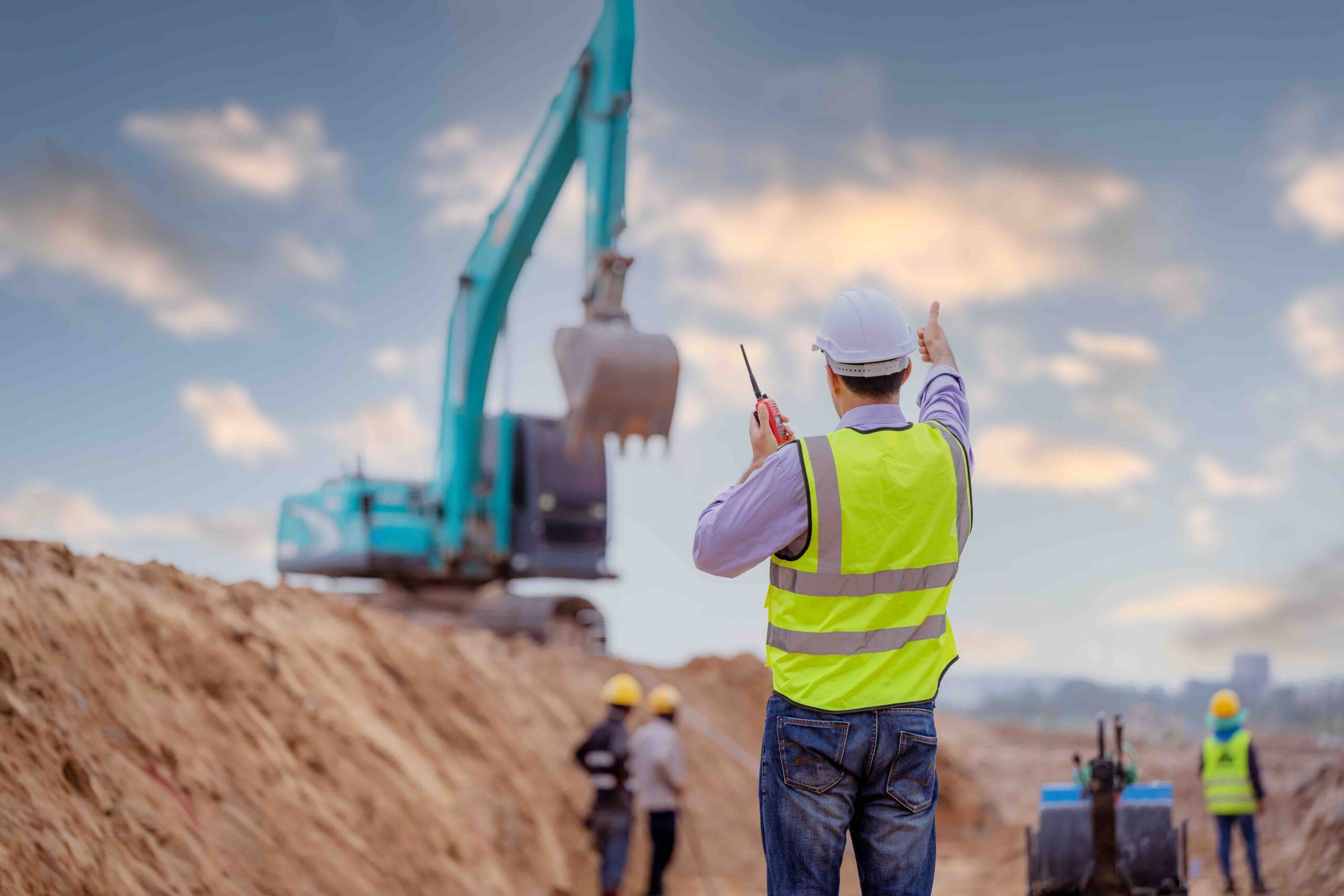 Construction project engineer directing excavator to sell select fill near me.